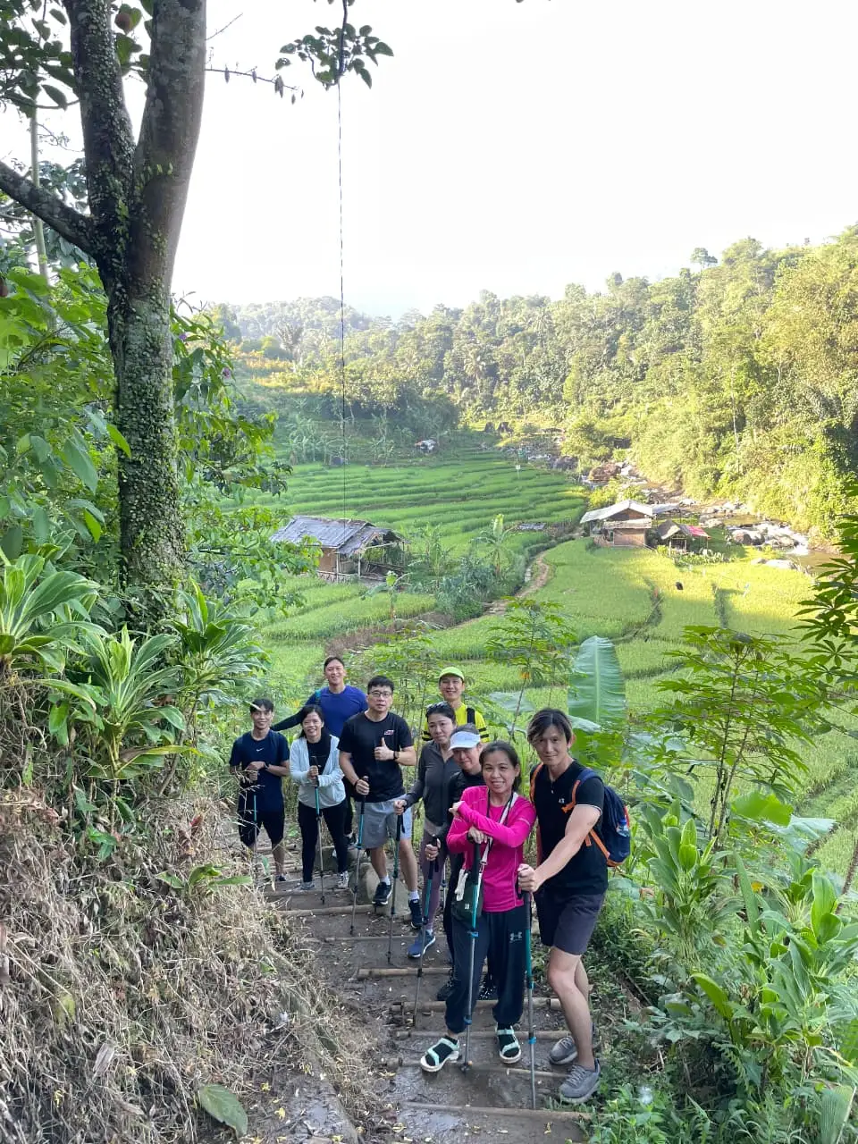 Tiga sahabat berpose di atas batu di kolam curug yang airnya berwarna biru kehijauan.