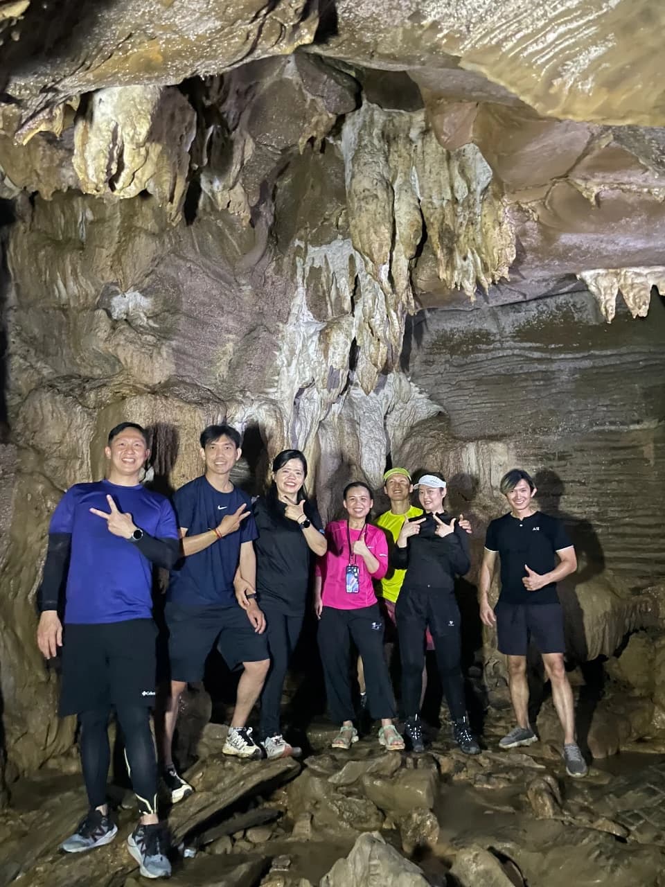 Grup peserta wanita berpose dengan gaya unik saat berdiri di aliran sungai yang dangkal.